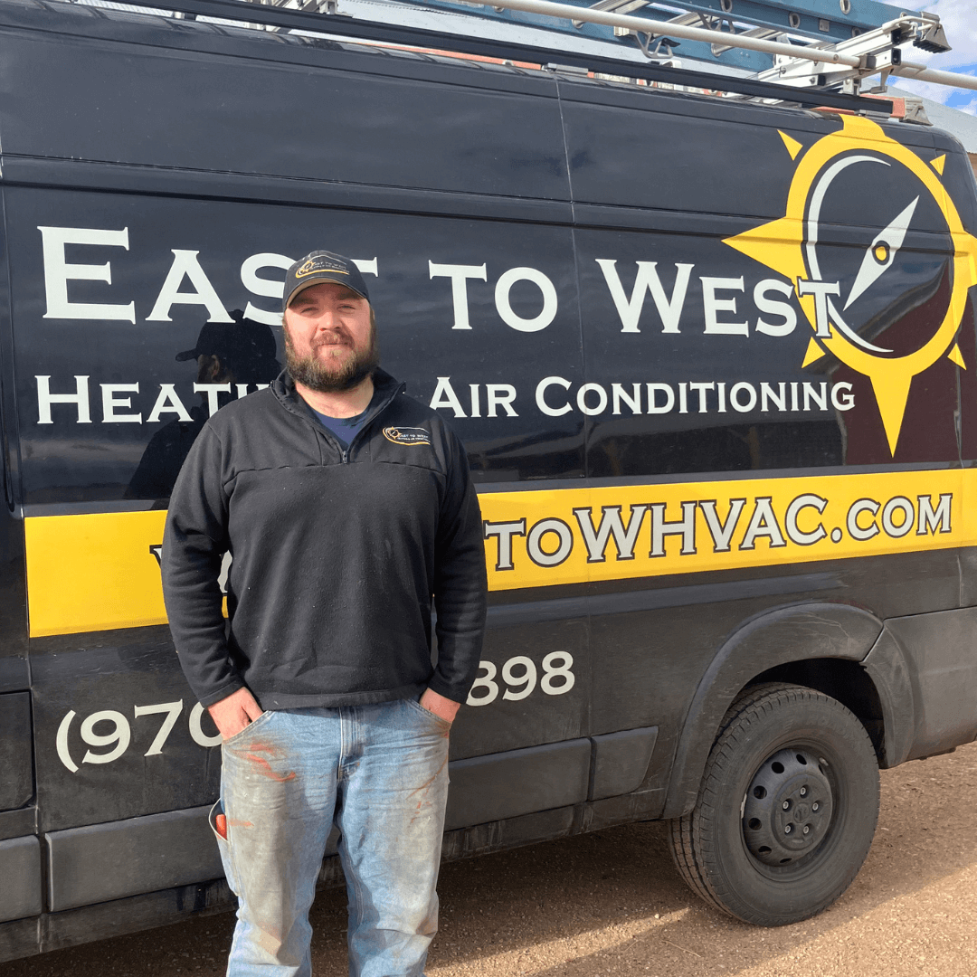 Nate Simond, Owner of East to West Heating & Air Conditioning, standing next to company truck