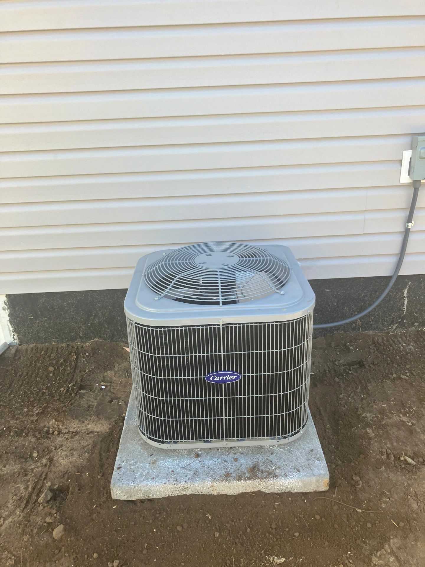 Professional Carrier AC installation - outdoor condenser unit on concrete pad