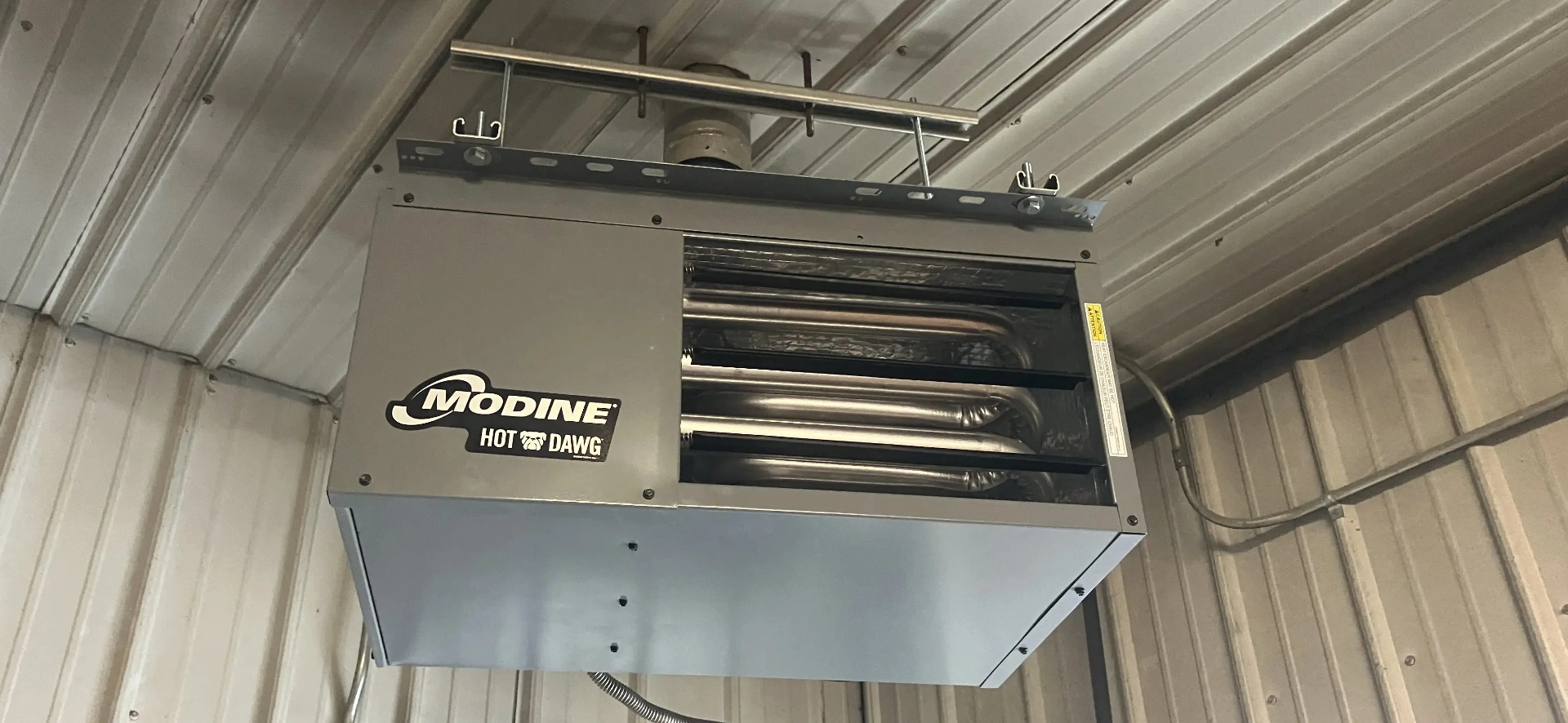 Modine Hot Dawg unit heater installation showing professional mounting in commercial garage setting