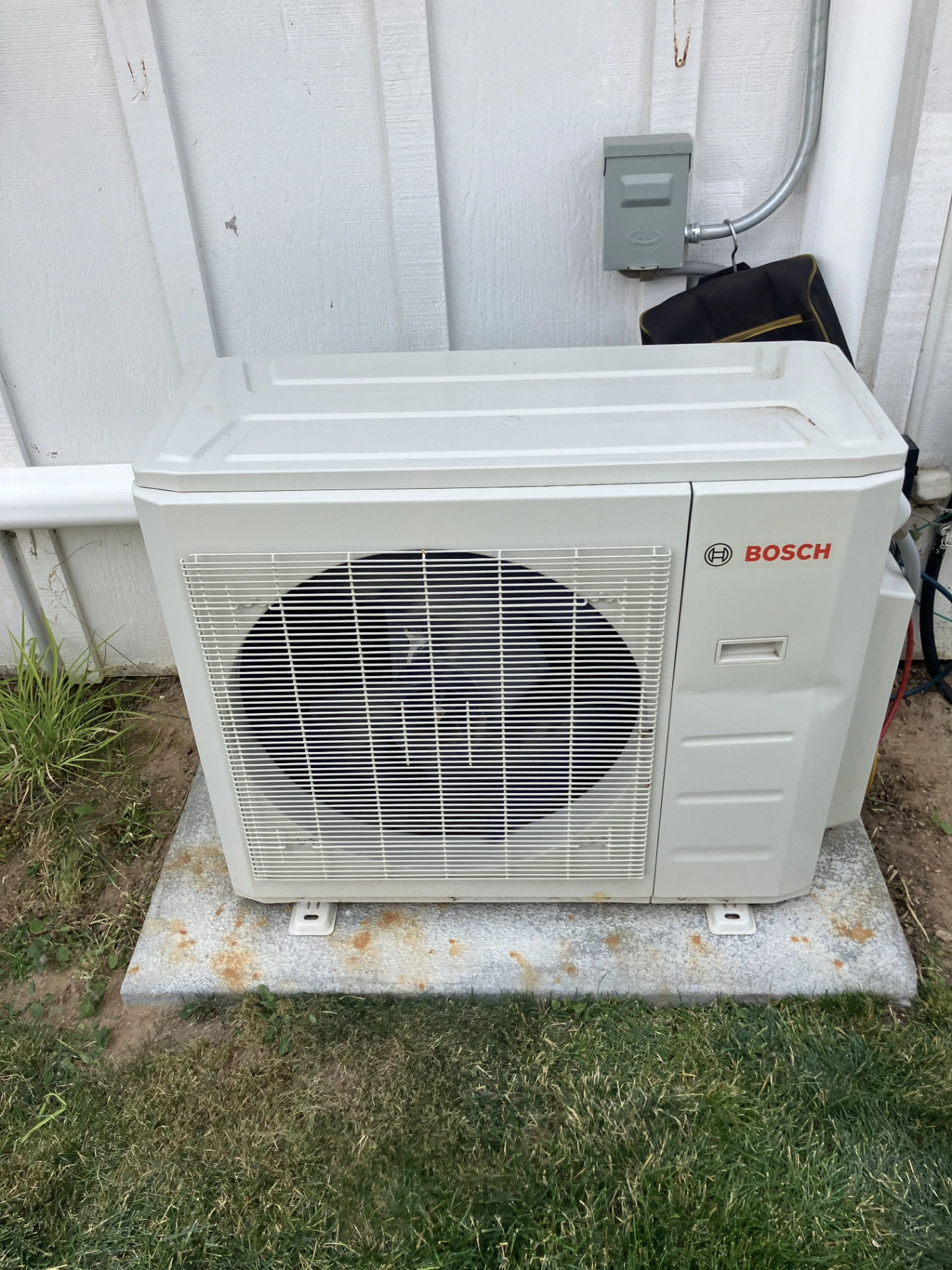 Bosch heat pump outdoor unit professionally installed on residential property with proper clearances and connections